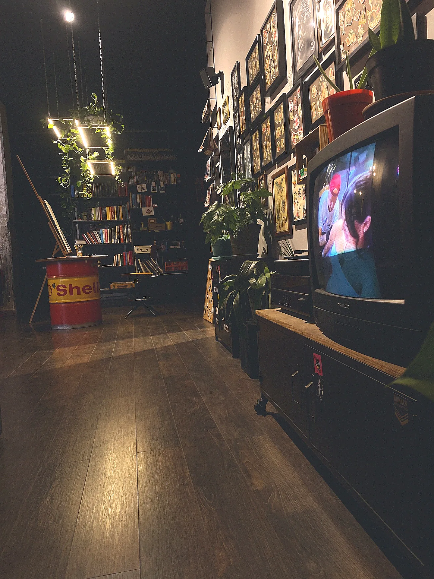 Interno dello studio con TV vintage, disegni incorniciati e libreria