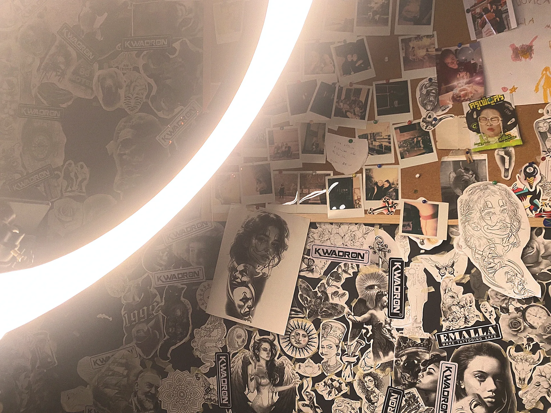 Postazione del tatuatore con ring light, foto e adesivi alla parete